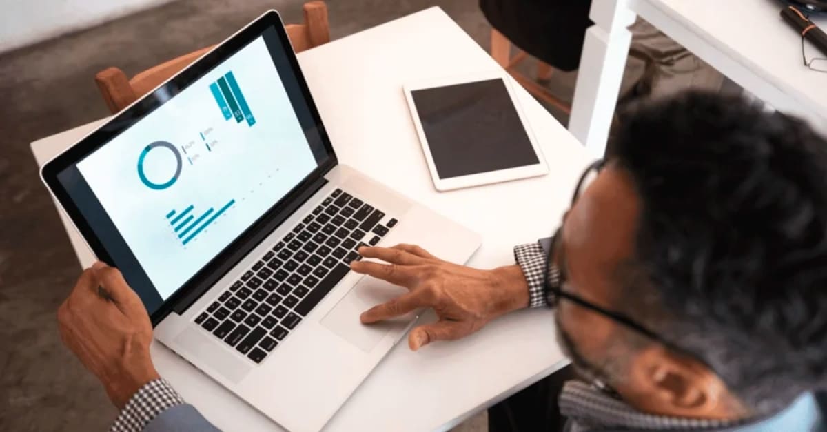 Man on his laptop with graphs displayed