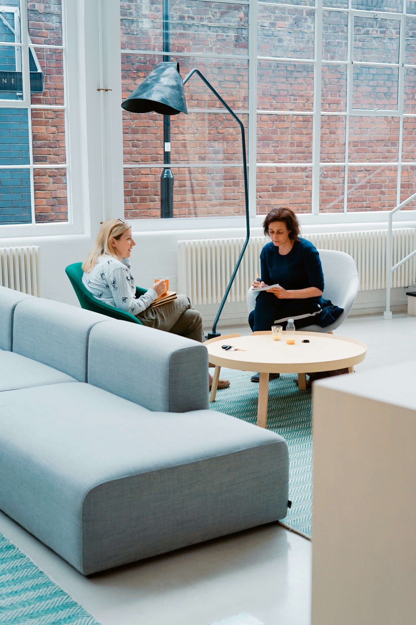 Two women sitting on couch office