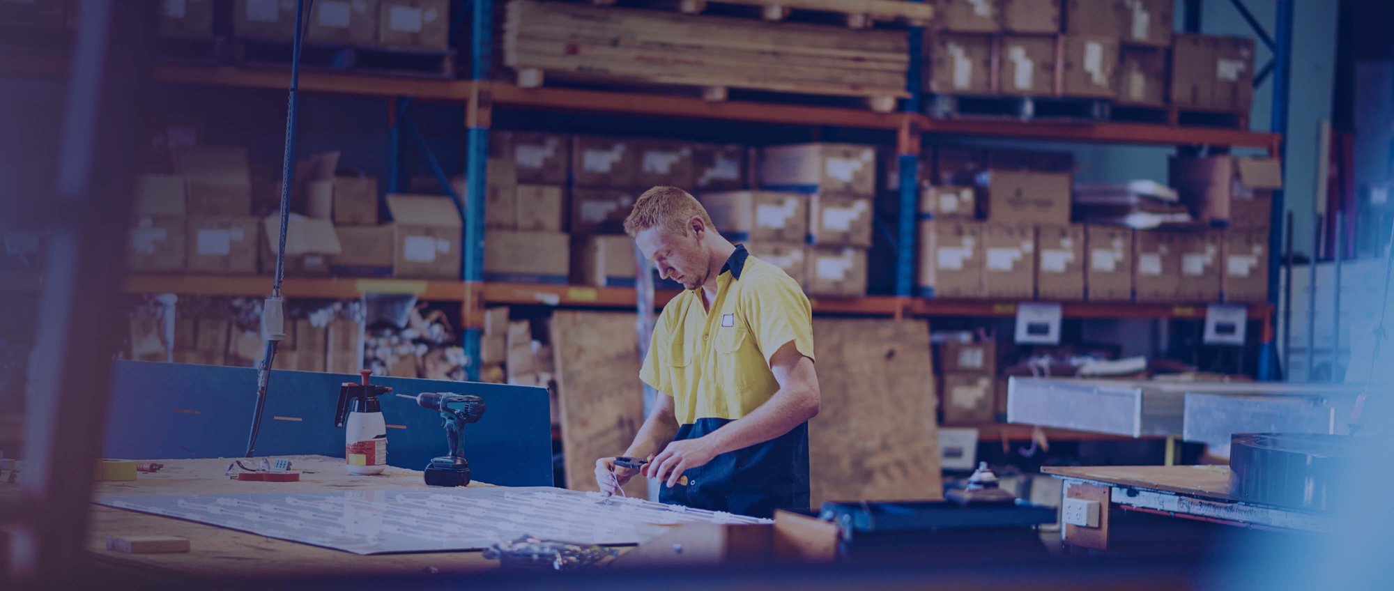 Warehouse worker with tools on desk