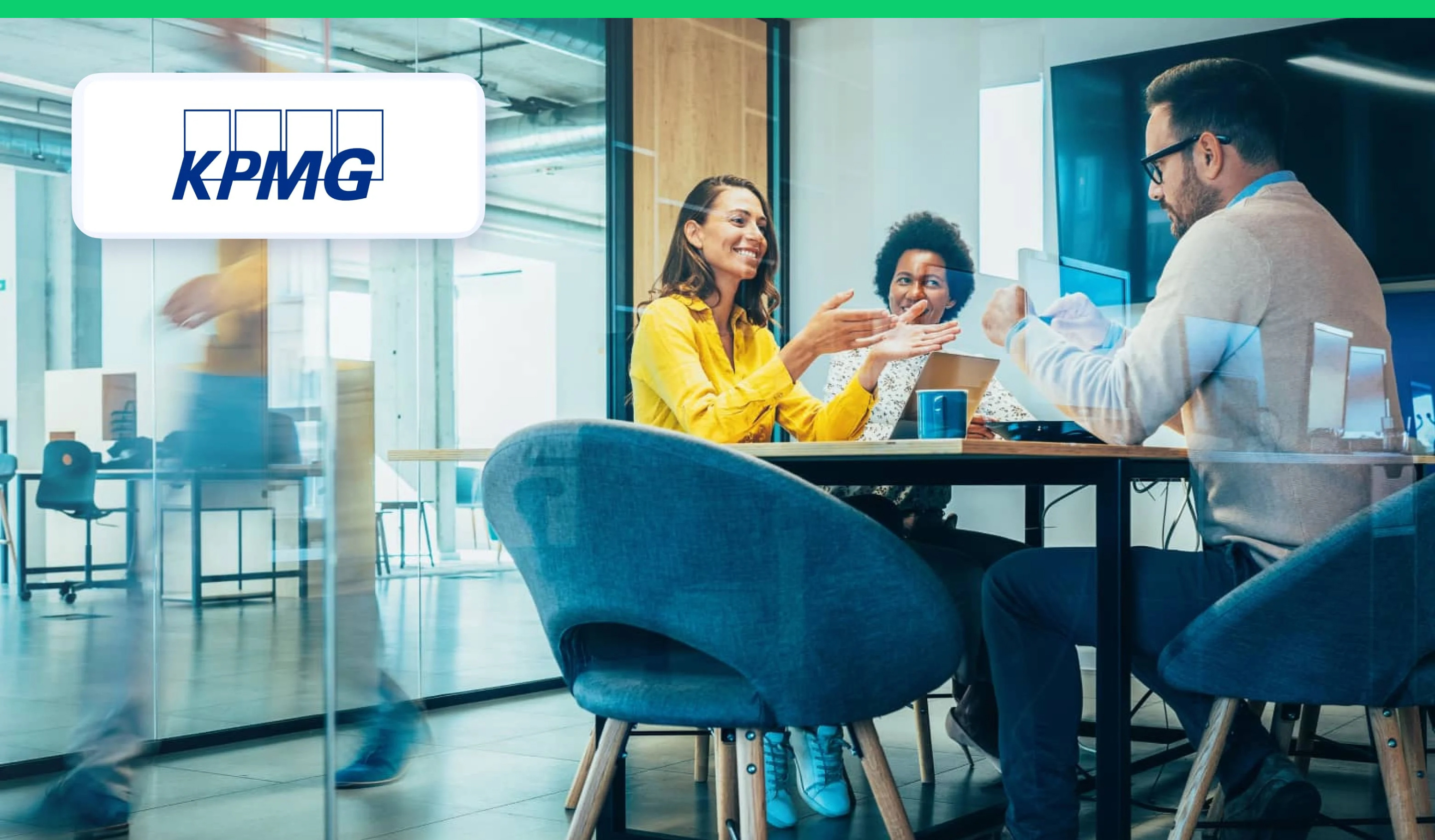 Workers sitting at desk in office talking with KPMG